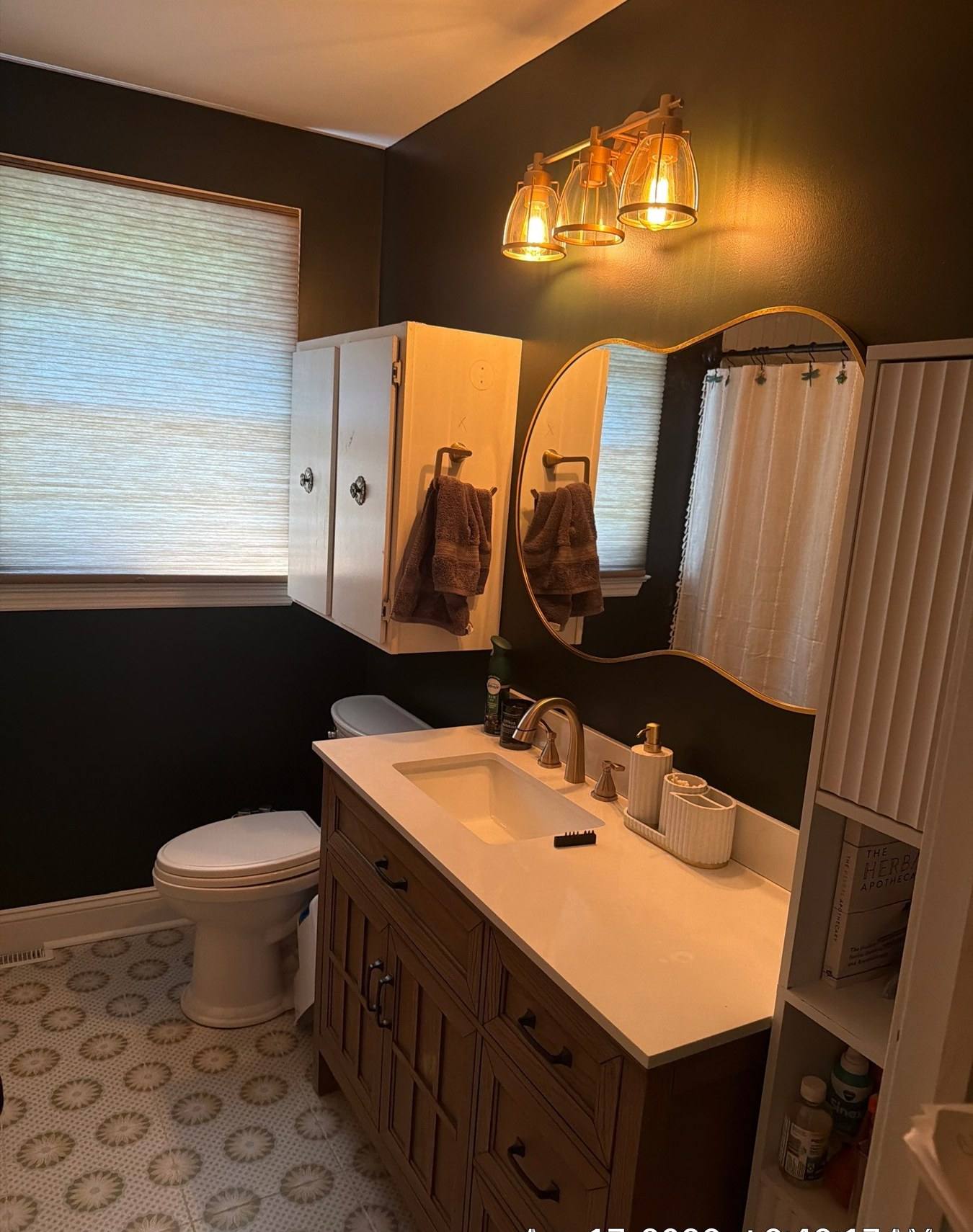 Double vanity with gold sconces in a remodeled Cayce, SC bathroom