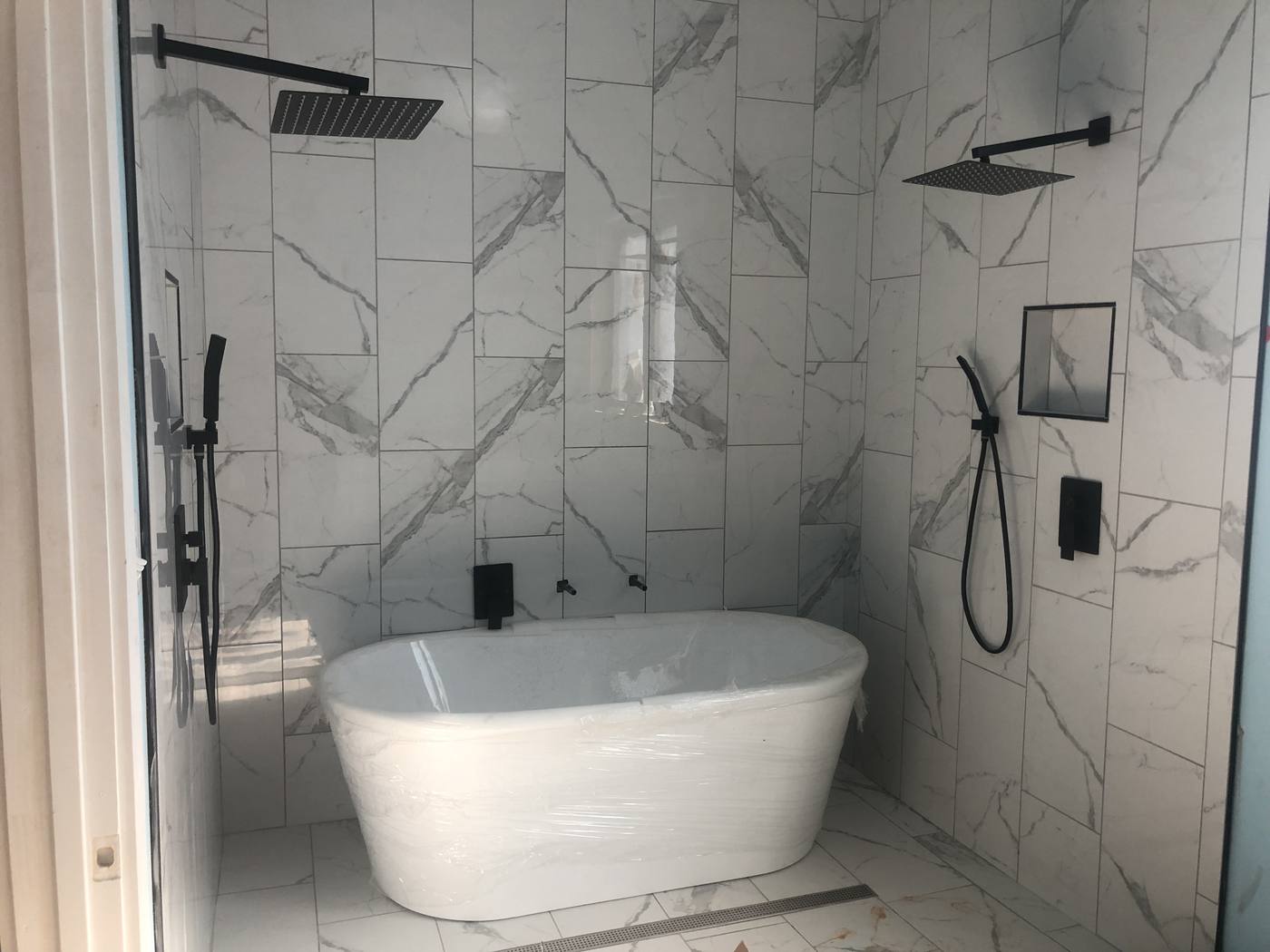 Marble wet room with a freestanding tub, rainhead shower and matte black fixtures in the Midlands of South Carolina