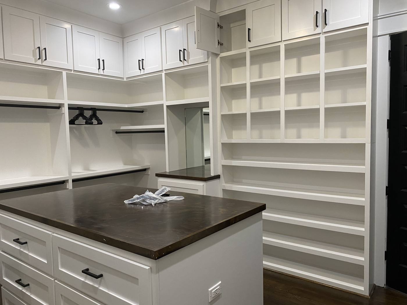 Custom primary closet with built-in shelving and a center island with drawers in the Midlands of South Carolina