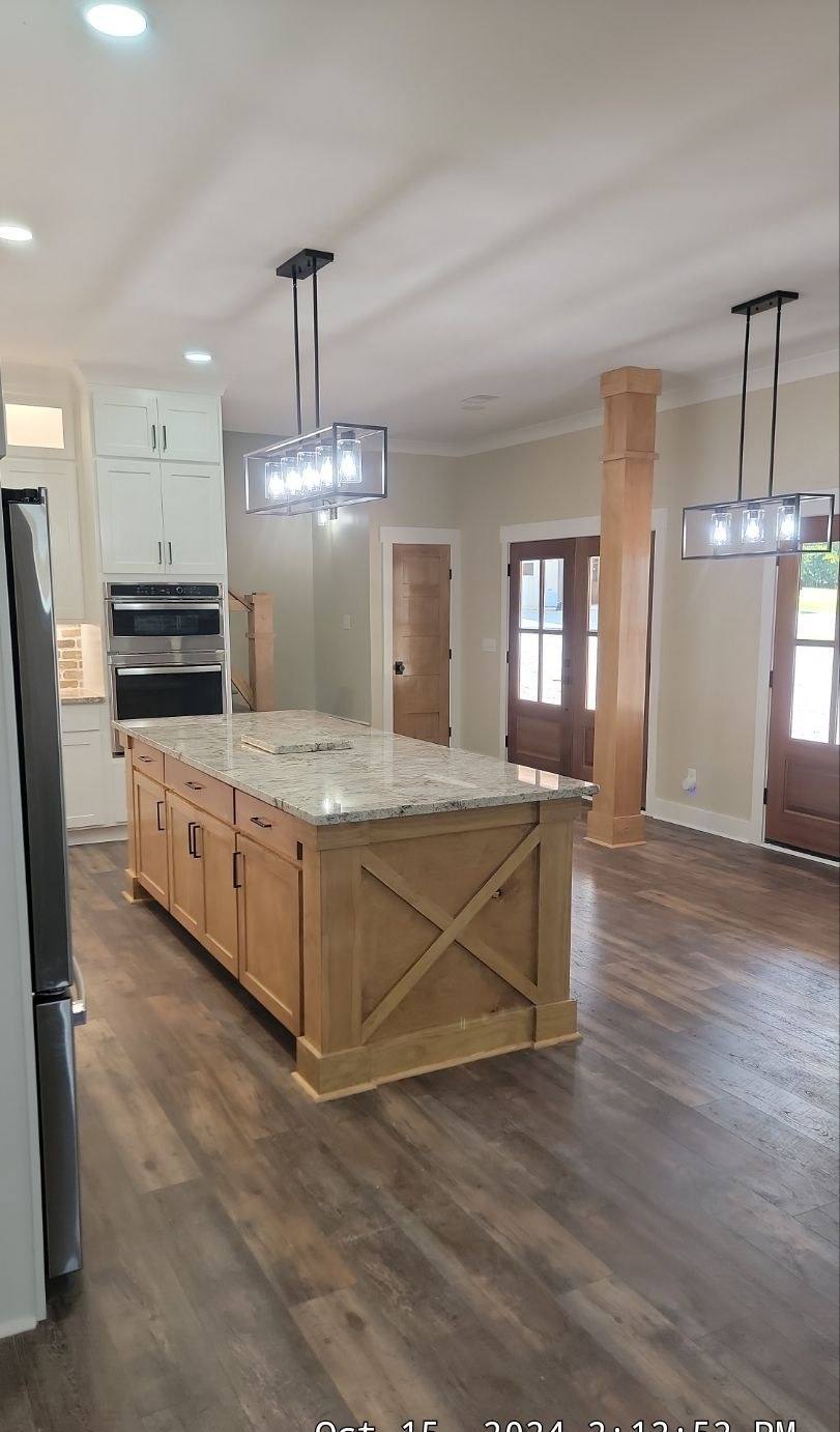New kitchen with large island and custom range hood in a Batesburg-Leesville custom home
