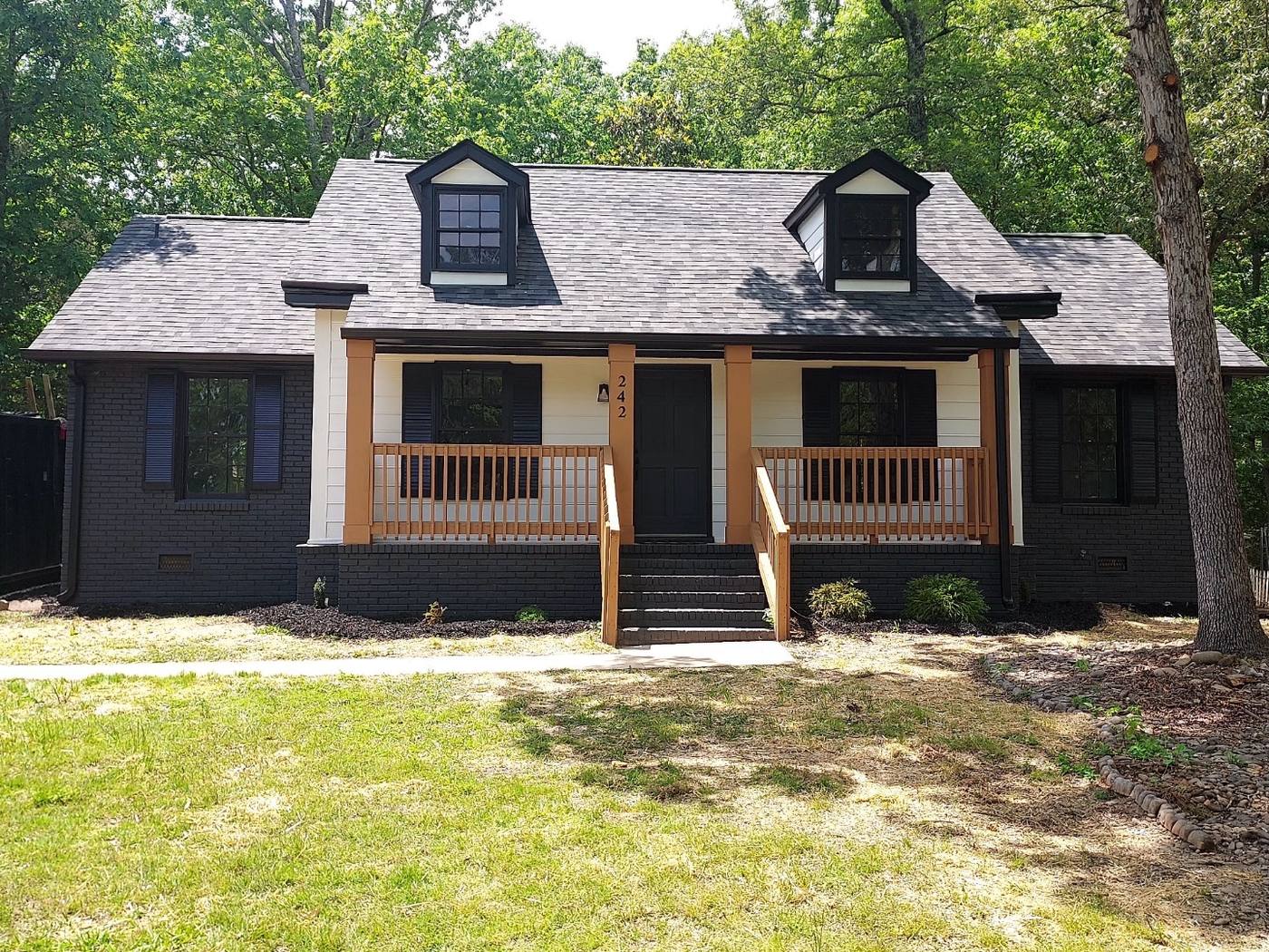 Renovated ranch with black siding, cedar porch posts and new dormers in the Midlands of South Carolina