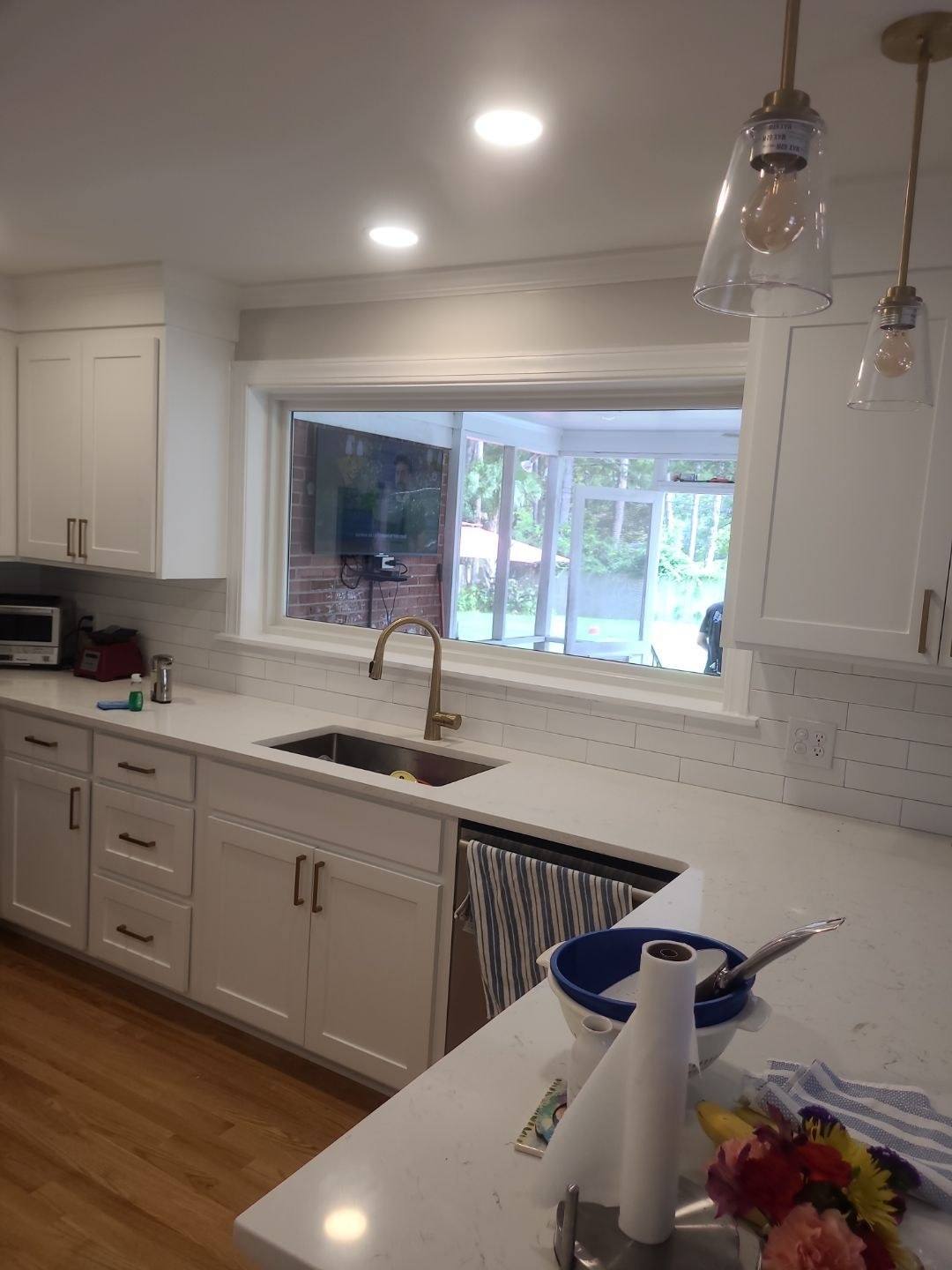 Remodeled white kitchen with pendant lighting and a wide window over the sink in Forest Acres, Columbia SC