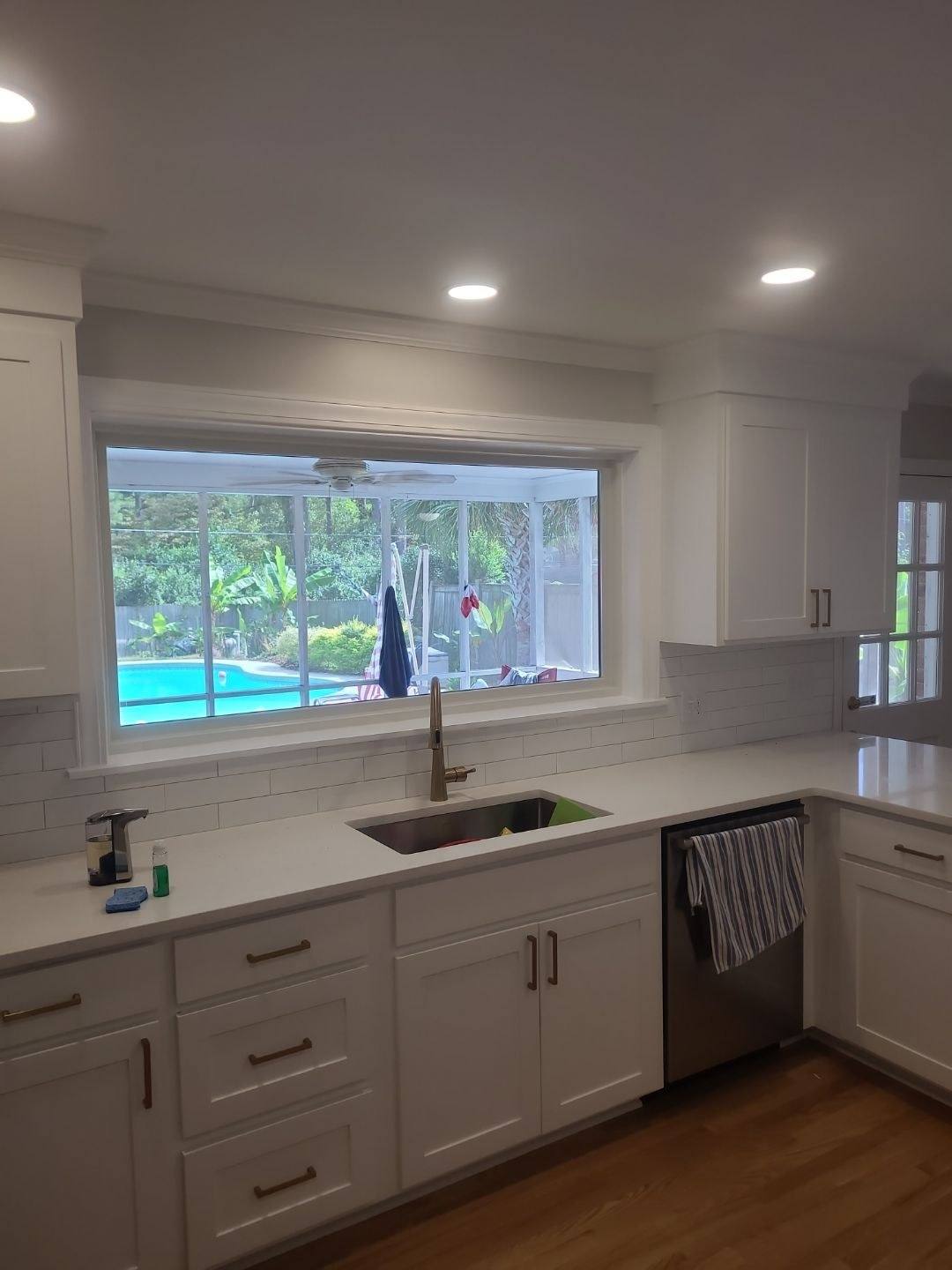 New quartz counters, white shaker cabinetry and a picture window in a Forest Acres kitchen