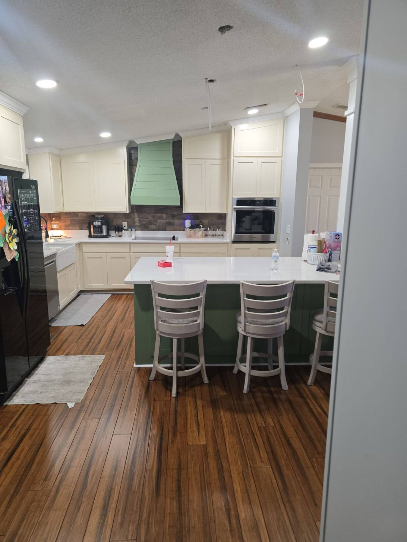 Remodeled kitchen with a sage green island, bar seating and hardwood floors in Gilbert, SC