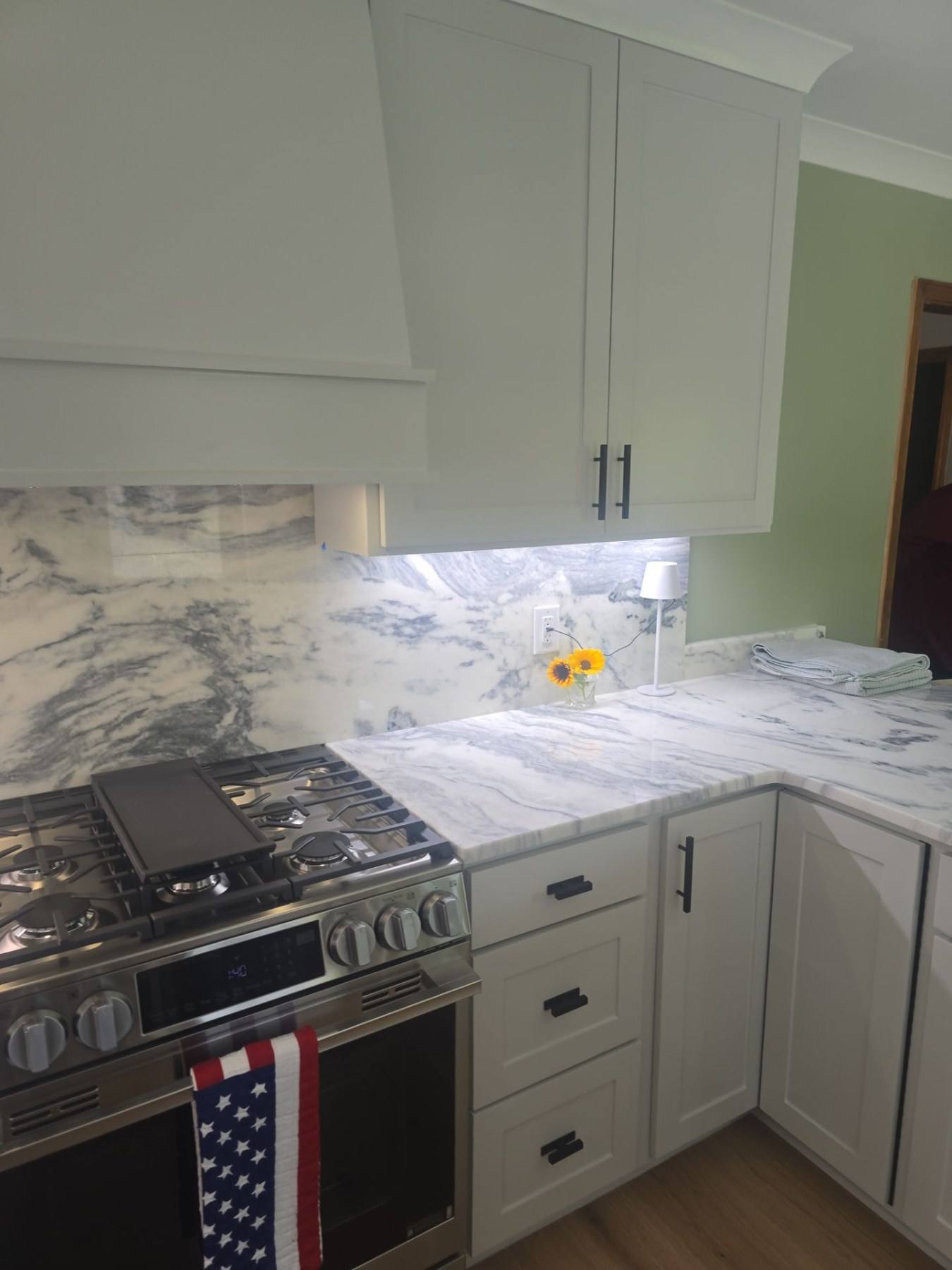 Gas range and marble backsplash in a rebuilt Lexington kitchen
