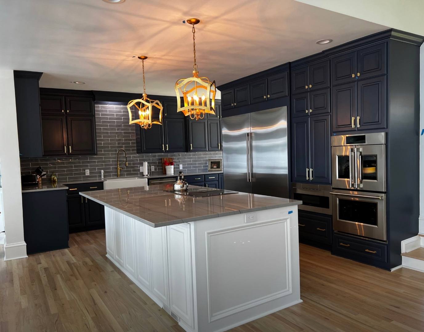 Remodeled kitchen with navy cabinetry, a white quartz island and double wall ovens in the Midlands of South Carolina