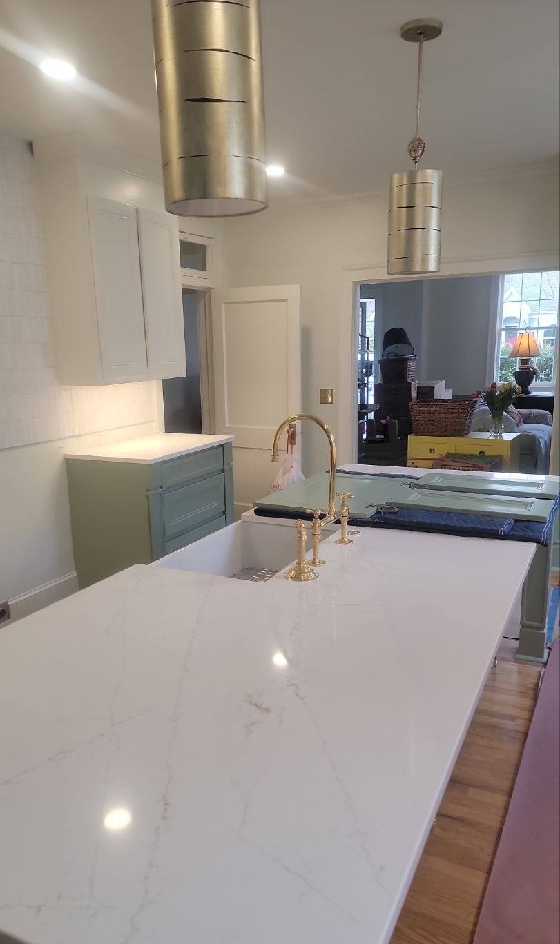 Finished sage green kitchen with a quartz island after a storm rebuild in Shandon, Columbia