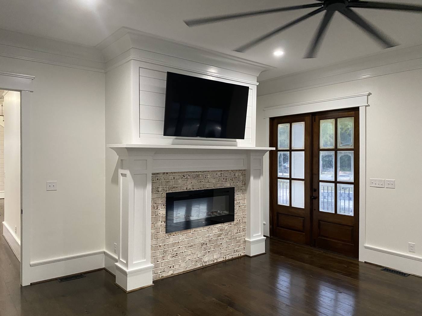 New living room with a tiled linear fireplace, shiplap surround and french doors in the Midlands of South Carolina
