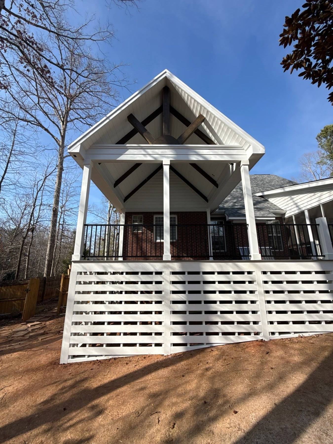 Rebuilt gabled screened porch with timber trusses and lattice skirting in Lexington, SC