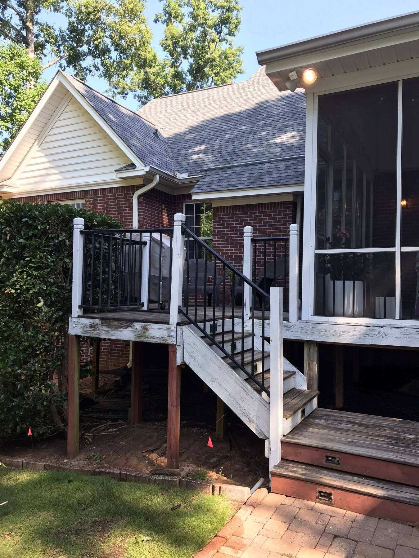 Aging screened porch and wood stairs on a brick home before rebuilding in Lexington, SC