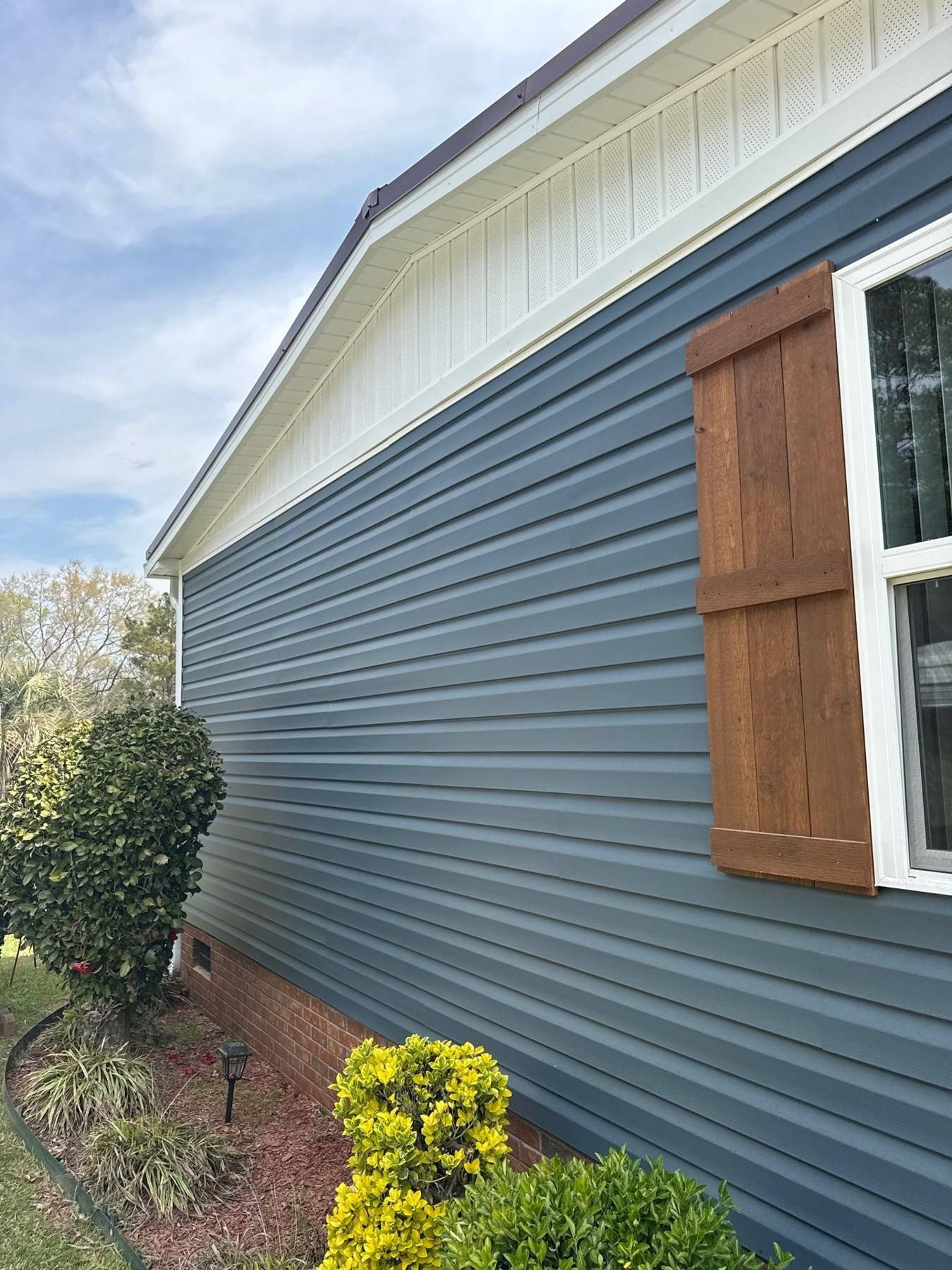 New blue vinyl siding and cedar accent on a renovated home in Prosperity, SC
